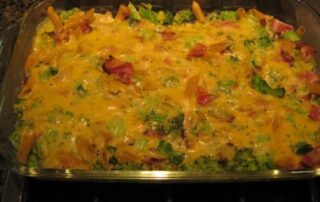 A casserole dish with broccoli, cheese and bacon.
