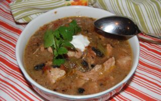 A bowl of chicken chili with sour cream and sour cream.